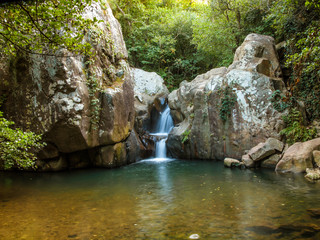Fototapeta na wymiar small waterfall in a green forest