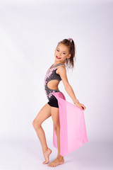 Flexible little girl gymnast doing acrobatic exercise on white background