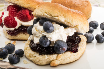 english scone with whipped cream, raspberry and blueberry