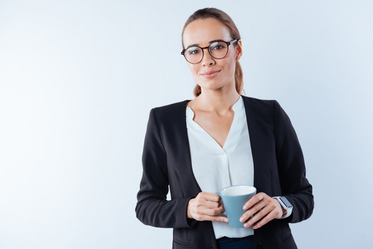 Serious smart businesswoman holding coffee