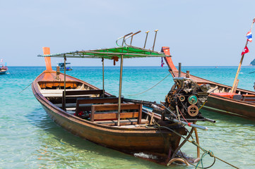 Naklejka na ściany i meble Long boat with engine and tropical beach