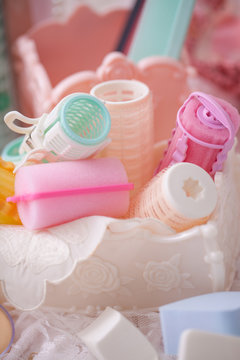 Cosmetic hair roll in mix candy color and makeup brushes.