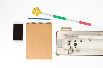 top view of notebook and pencil with sewing machine concept for designer business. flat lay style