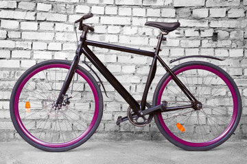 Fototapeta na wymiar Black fixed urban bike against black and white brick wall