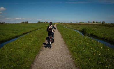 Obraz premium Girl on bike in Dutch fields