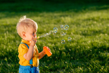 One year old baby boy blowing soap bubbles