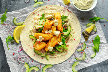 Fresh Fish Tortilla with cucumber, red onion, Capers, lemon, salad leaves and tartare sauce. Healthy Food