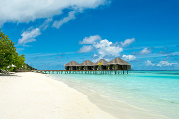 Beautiful sandy beach with sunbeds and umbrellas in Indian ocean, Maldives island