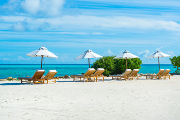 Beautiful sandy beach with sunbeds and umbrellas in Indian ocean, Maldives island