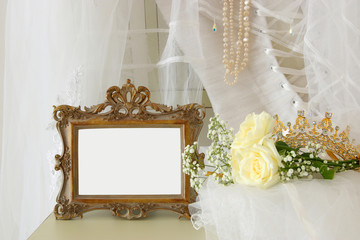 Old vintage oval mirror and beautiful white wedding dress and veil on chair