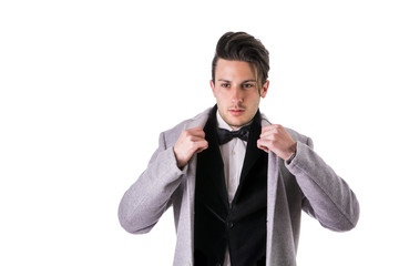 Young businessman confidently posing and looking at camera, wearing suit isolated on white background