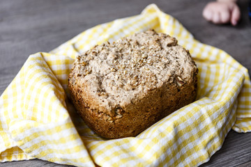 home made cereal bread in yellow cloth on wooden table