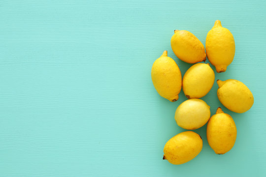 Top view of fresh lemons over blue wooden background