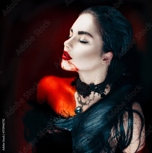 "Beauty Halloween sexy vampire woman with dripping blood on her mouth" Stock photo and royalty