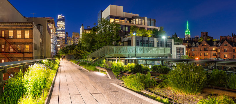 Fototapeta Panoramic view of the High Line promenade at twilight with city lights and illuminated skyscrapers. Chelsea, Manhattan, New York City