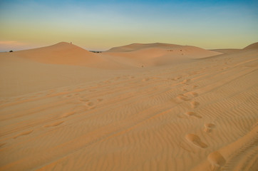 Beautiful white sand dunes ripples and footprint in sunrise morning, White Sand Dune at Muine, Vietnam. Vacation concept background.