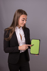 Fototapeta premium Attractive businesswoman with tablet studying news and presentation ideas. Project management and Corporate services. Tablet has empty green and copy space.