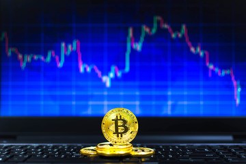 gold bitcoins on key board and BTC trading chart in background, Financial concept