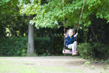 Little girl playing with a swing