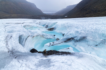 Smeltwaterstroom die stroomt van de Longyear-gletsjermorene in het Noordpoolgebied, Svalbard. Ontdooien van gletsjers en het probleem van de opwarming van de aarde.