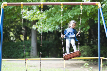 Little girl playing with a swing