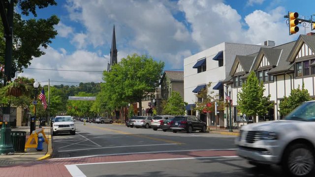A daytime establishing shot of an intersection in the business district in the upscale small town of Sewickley, about 15 miles north of Pittsburgh.  	