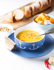 Fototapeta na wymiar Creamy pumpkin soup on the table, selective focus, vertical 
