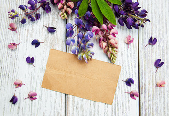 Lupine flowers with vintage card on a  table