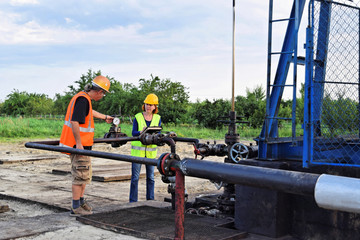 Two engineers  at work on an European oil well   