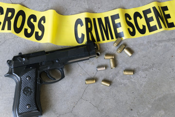 Crime scene concept with bullet casings and black gun