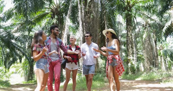 People Group With Backpacks Talking Trekking On Forest Path, Young Men And Woman On Hike Tropical Palm Tree Park Tourists Slow Motion 60