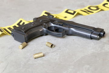 Crime scene concept with gun and three casings