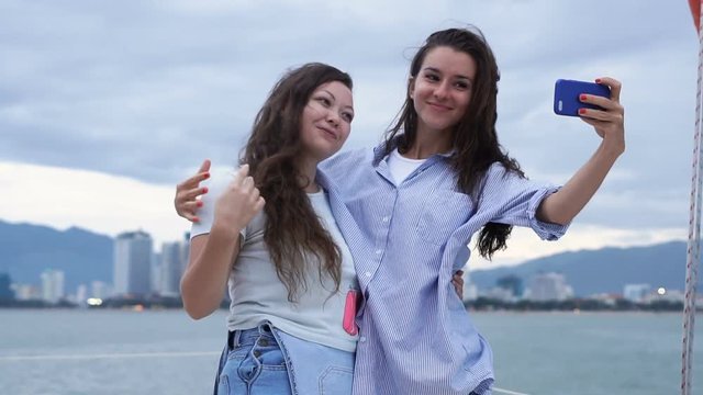 Two girls taking selfie while enjoying a cruise on a yacht
