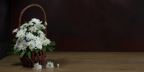 Fototapeta na wymiar Still Life with white flowers (Chrysanthemum) in the basket