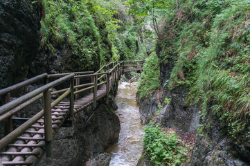 Wooden path running along the cliff and over the river gorge