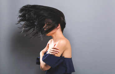 Young woman with floating hair on a solid background