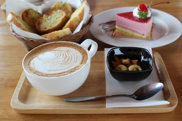 Hot cappuccino, biscuit, cake and bread in morning time.