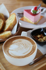 Hot cappuccino, biscuit, cake and bread in morning time.