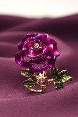 Gold brooch rose with diamonds on a silk fabric