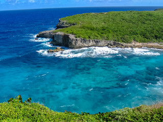 The famous Porte d'Enfer north of Grande-Terre in Guadeloupe. It is a gorge that protects a bay and a beach within it, by the rushing waves of the ocean by a coral reef at the entrance of the lagoon.