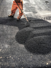 a worker asphalt road in the summer