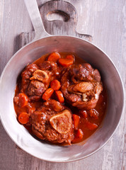 Osso buco (braised veal shank) with vegetables and gravy.