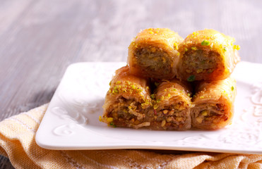 Baklava with pistachios and honey on plate