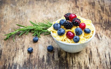 Golden corn flakes and fresh berries. Cranberries, blueberries and blackberries. Useful breakfast