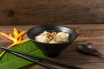 Shrimp wonton with braised pork in soup on wooden table - Asian food style  / Select focus image
