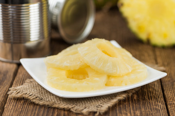 Wooden table with Preserved Pineapple Rings, selective focus