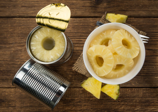 Portion of Preserved Pineapple Rings on wooden background, selective focus