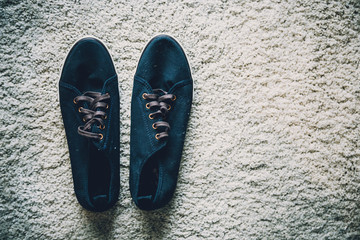 navy blue color men shoe on white shaggy rug texture background