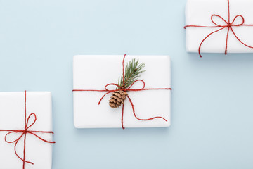 Christmas Gifts wrapped in white paper and red bow.
