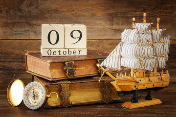 Columbus day concept with old ship over wooden background